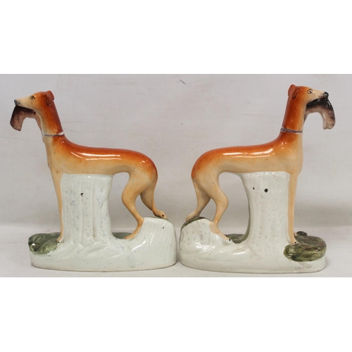 195 - Pair of Staffordshire Pottery figures of greyhounds, each standing on naturalistic oval plinth base,... 