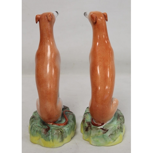 196 - Pair of Staffordshire Pottery greyhounds, each seated on naturalistic domed plinth base, each 21cm h... 