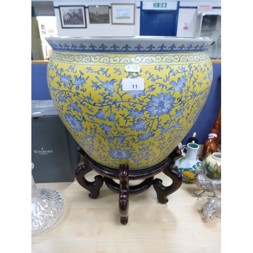 11 - Modern Chinese pottery fish bowl with floral decoration on yellow ground, on stand.