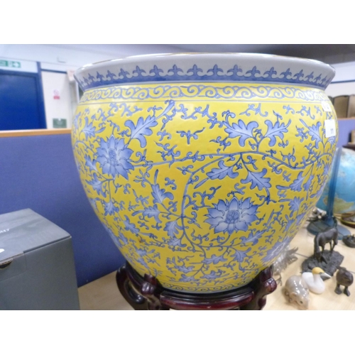 11 - Modern Chinese pottery fish bowl with floral decoration on yellow ground, on stand.