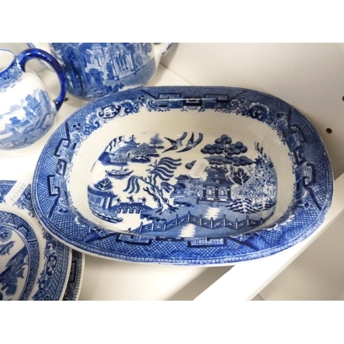 124 - Collection of 'Willow' pattern blue and white tableware including cups and saucers, rum butter bowl,... 