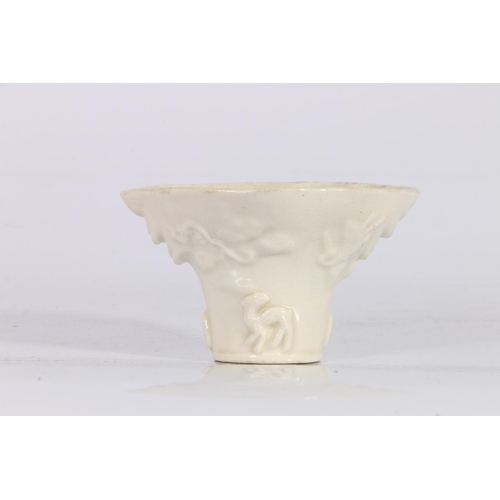 416 - 19th century blanc-de-chine libation cup, decorated in relief with a tiger and a deer beneath blosso... 