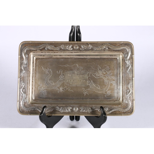 438 - Chinese silver card tray of rectangular shape, on four ball feet, decorated with dragons on a punche... 