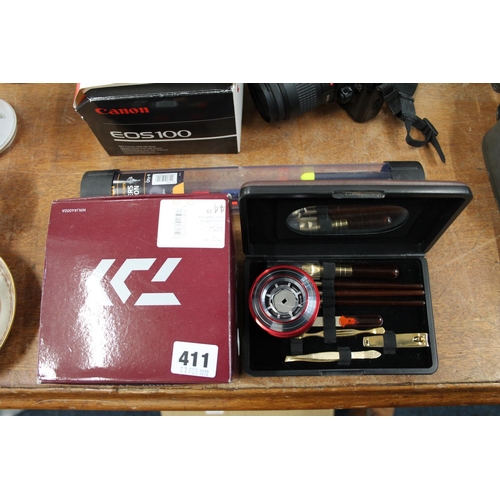 411 - Ninja 400A fishing reel, a manicure set, and fishing floats.