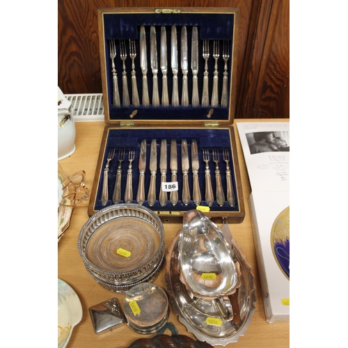 186 - Silver-plated knives and forks, a wine slide, a gravy boat, etc.