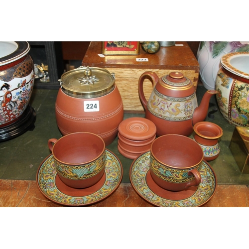 224 - Victorian terracotta ware to include biscuit barrel, teapot, cups and saucers, etc.