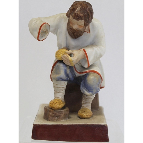 524 - Russian Moscow/Gardner bisque porcelain figure of a seated man braiding lapti (bast shoes). Painted ... 