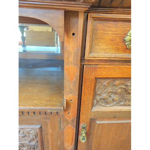 561 - Late 19th century light oak sideboard, the arched raised back with dentil cornice and foliate carved... 