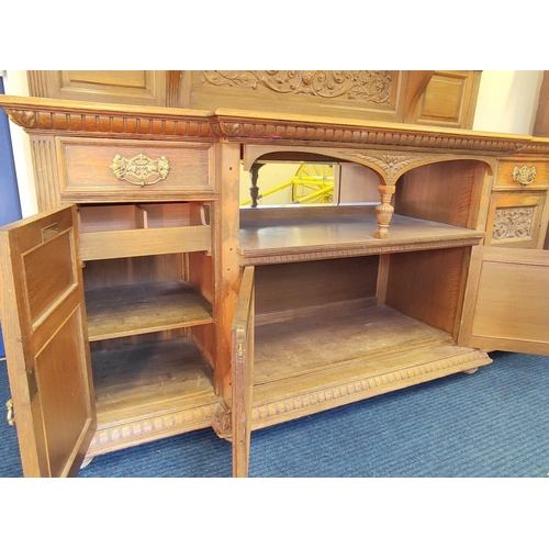 561 - Late 19th century light oak sideboard, the arched raised back with dentil cornice and foliate carved... 