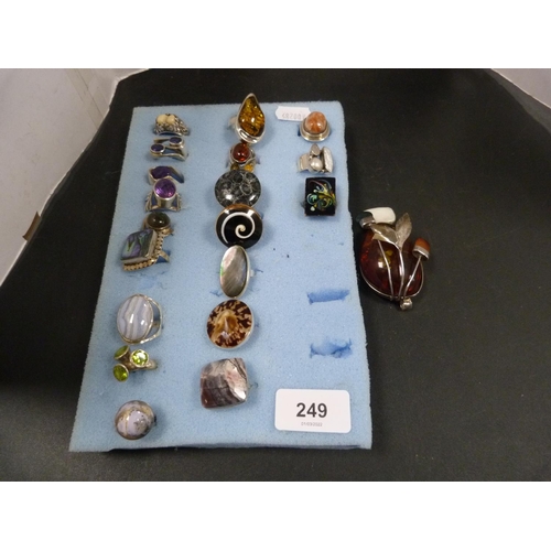 249 - Silver and white metal dress rings decorated with simulated gemstones, also a silver amber-style pen... 