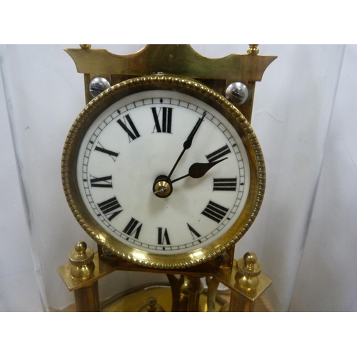 67 - Brass and gilt metal anniversary-style clock under a glass dome.