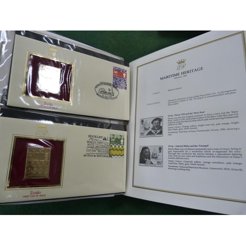 99 - Folder containing 22ct golden replicas of British stamps.