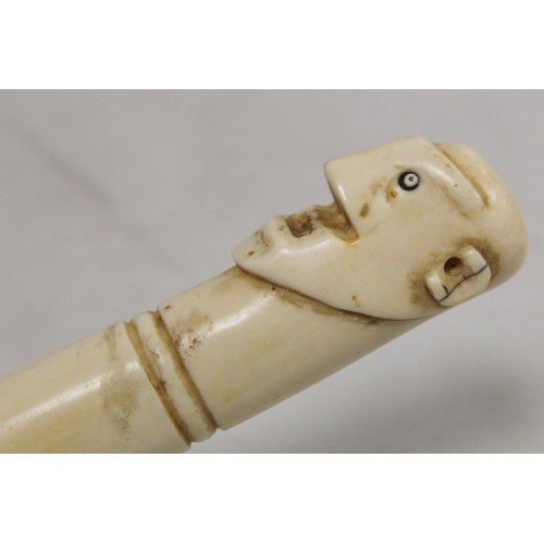 336 - Late 19th/early 20th century African carved ivory pipe with mask terminal and ribbing to body, 45cm ... 