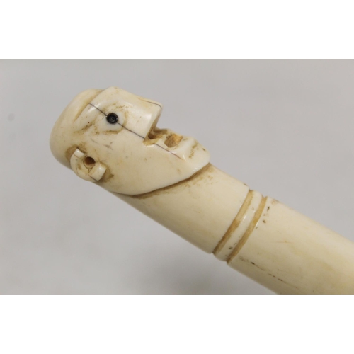 336 - Late 19th/early 20th century African carved ivory pipe with mask terminal and ribbing to body, 45cm ... 