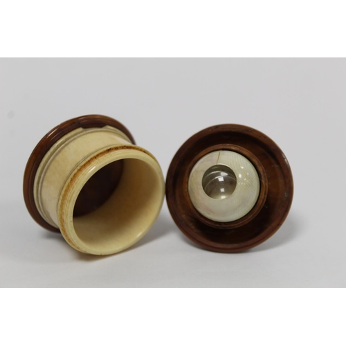 339 - Turned ivory and coquilla nut box of cylindrical form containing a model of an eyeball with removeab... 