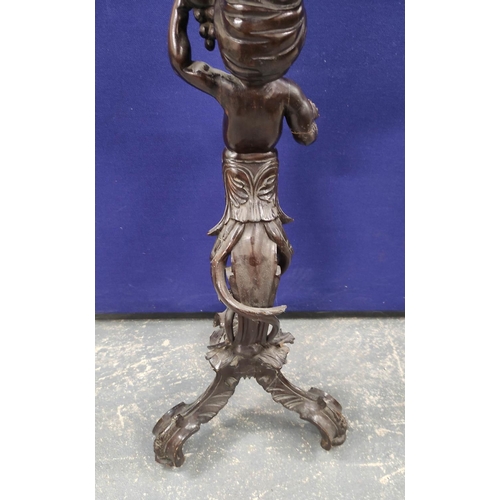 552 - Italian style carved wood torchere, modelled as a semi-clad putti holding grapes, on carved scroll t... 