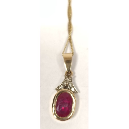 68 - Ruby pendant with diamond set loop, in coloured gold and the matching earrings.