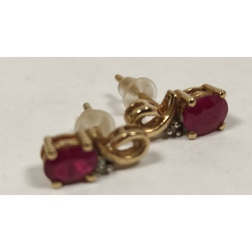 68 - Ruby pendant with diamond set loop, in coloured gold and the matching earrings.