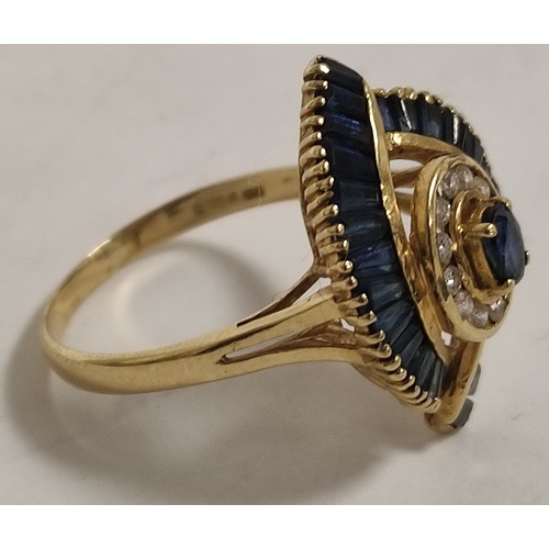 69 - Dress ring with an oval sapphire and diamond cluster and baguette sapphires, in 18ct gold, 198g, siz... 