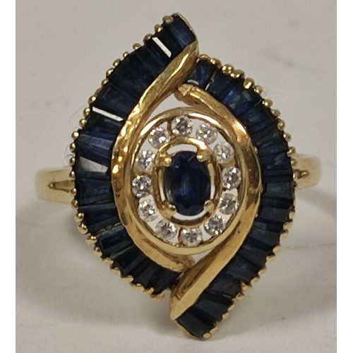 69 - Dress ring with an oval sapphire and diamond cluster and baguette sapphires, in 18ct gold, 198g, siz... 