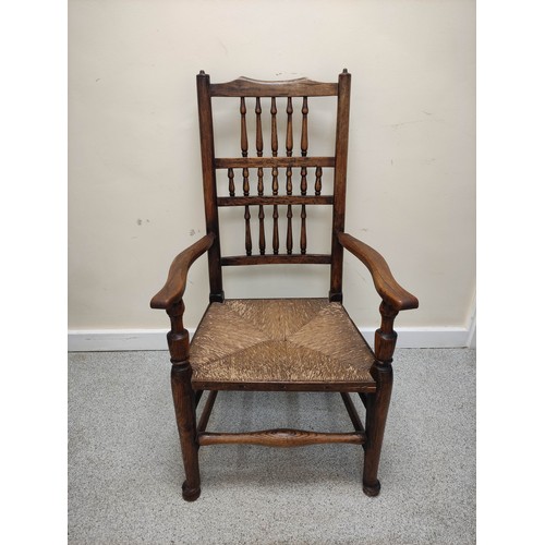 577 - 19th century oak rushwork Lancashire chair, with bobbin turned spindle back supports, raised on pad ... 