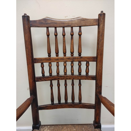 577 - 19th century oak rushwork Lancashire chair, with bobbin turned spindle back supports, raised on pad ... 