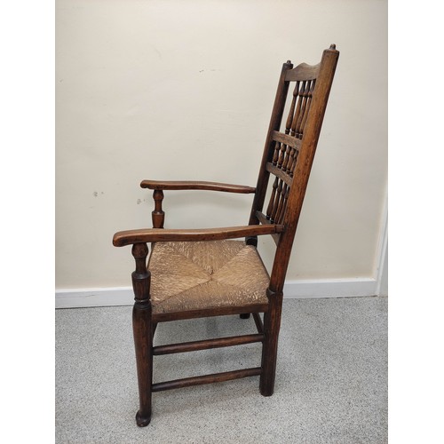 577 - 19th century oak rushwork Lancashire chair, with bobbin turned spindle back supports, raised on pad ... 