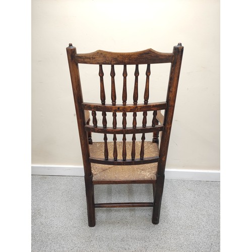 577 - 19th century oak rushwork Lancashire chair, with bobbin turned spindle back supports, raised on pad ... 