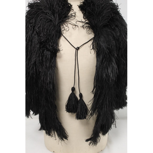 422 - Early 20th century black ostrich feather ladies cape with tasseled cord fastener and black rayon lin... 