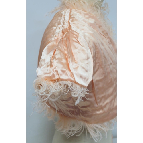 428 - Early 20th century bolero jacket of apricot ostrich feather with satin lining and ribbon tie.