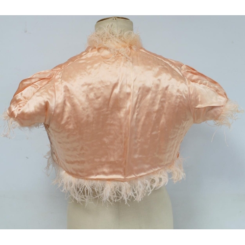 428 - Early 20th century bolero jacket of apricot ostrich feather with satin lining and ribbon tie.