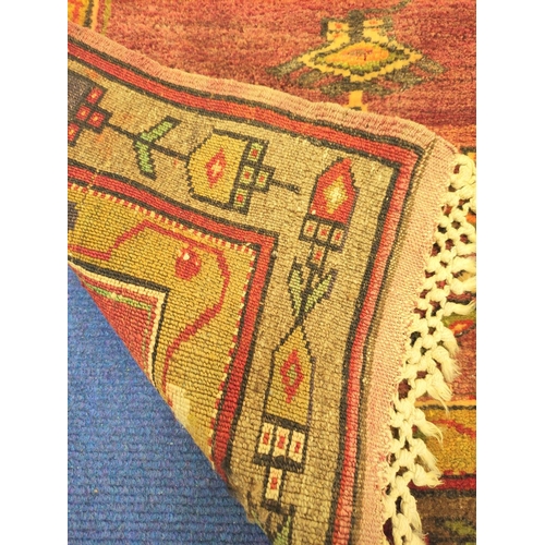 84 - Turkish wool rug with central panel decorated with diamond lozenges in a field of red, yellow and br... 