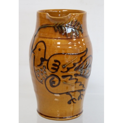 467 - Large studio pottery jug of ovoid form with ochre glaze and tube lined stylised decoration of a dove... 