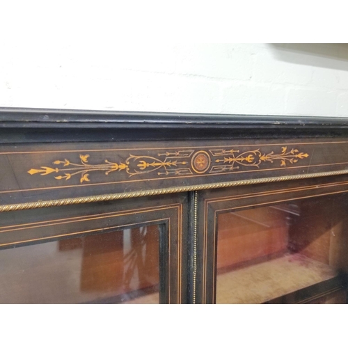 582 - Victorian ebonised and inlaid gilt metal mounted cabinet enclosed by pair of glazed doors on plinth ... 