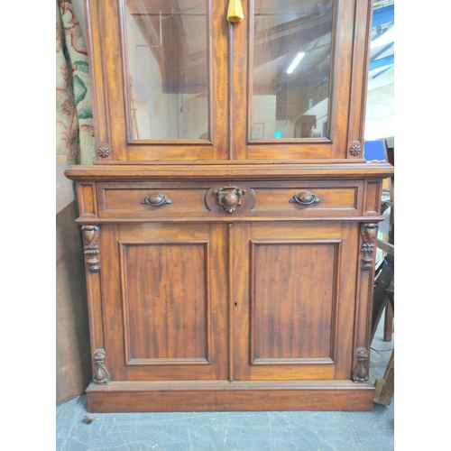 584 - Victorian carved mahogany cabinet bookcase, the upper section enclosed by pair of glazed doors over ... 