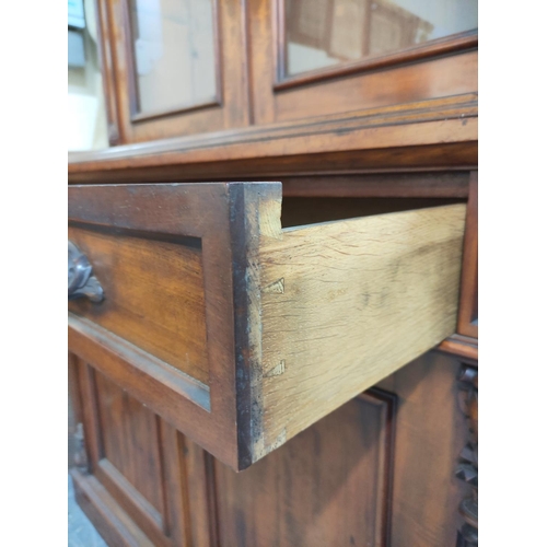 584 - Victorian carved mahogany cabinet bookcase, the upper section enclosed by pair of glazed doors over ... 