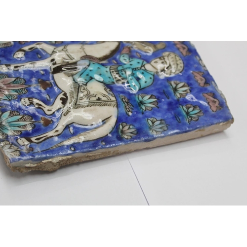 462 - Persian glazed tile or panel decorated in a typical Qajar manner with a figure on horseback hunting ... 