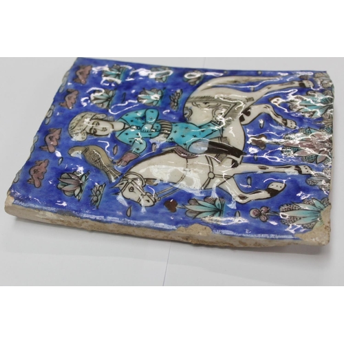 462 - Persian glazed tile or panel decorated in a typical Qajar manner with a figure on horseback hunting ... 