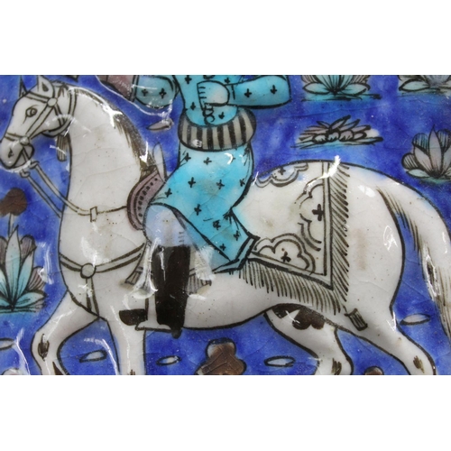 462 - Persian glazed tile or panel decorated in a typical Qajar manner with a figure on horseback hunting ... 