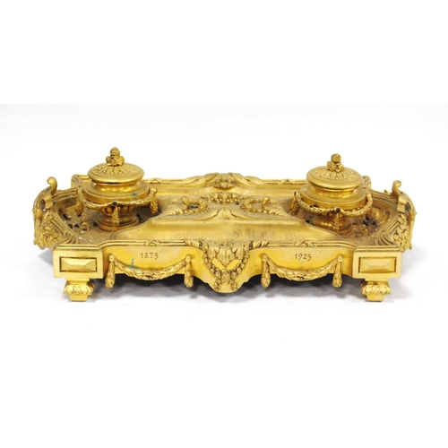 122 - Gilt metal desk stand with two integral inkwells, with two open quill wells and applied classical-st... 