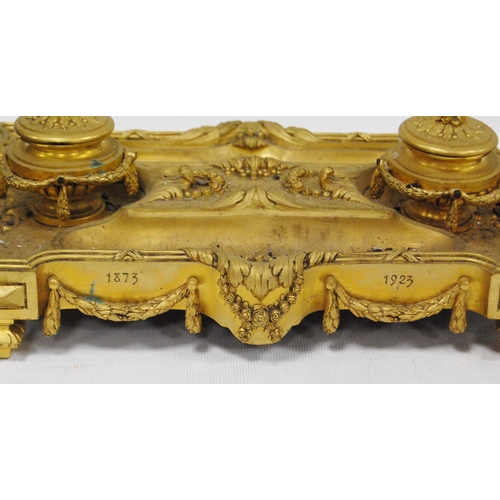 122 - Gilt metal desk stand with two integral inkwells, with two open quill wells and applied classical-st... 