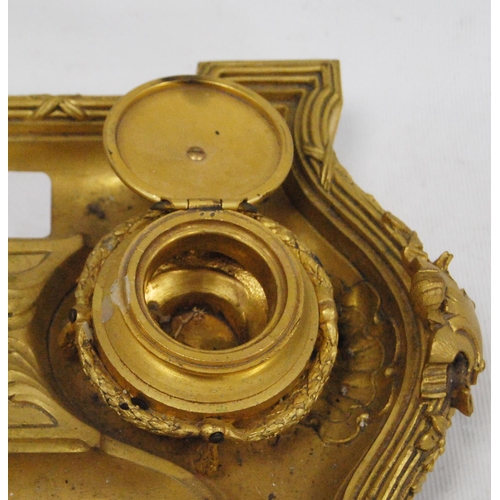 122 - Gilt metal desk stand with two integral inkwells, with two open quill wells and applied classical-st... 