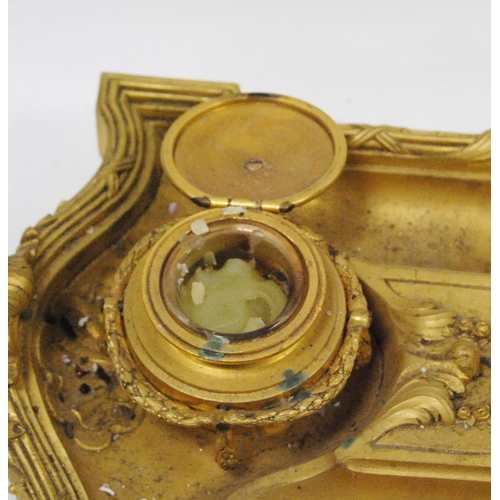 122 - Gilt metal desk stand with two integral inkwells, with two open quill wells and applied classical-st... 