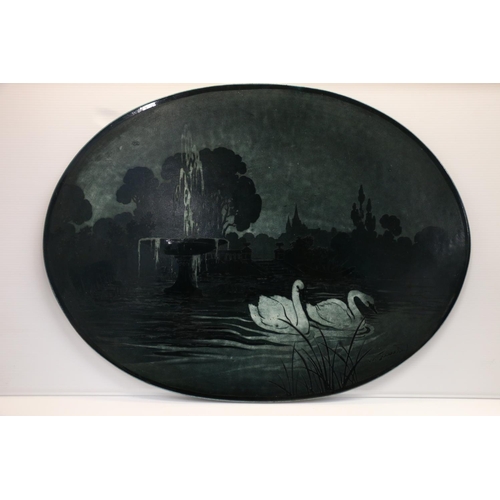 18 - Ceramic plaque with cameo style decoration depicting swans swimming, 51cm wide.