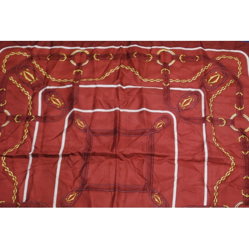 136 - Must de Cartier silk scarf on a claret ground, 83cm x 79.5cm, with original sleeve.