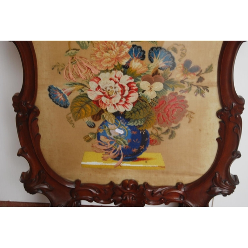 353 - Victorian mahogany fire screen, with a needlepoint panel to the centre depicting flowers in a vase, ... 