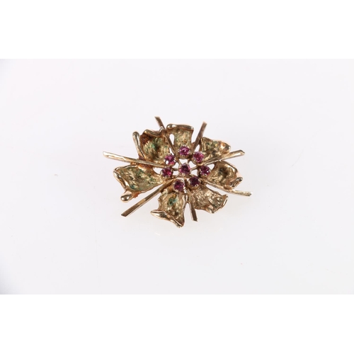 123 - 9ct gold floral design brooch, the flowerhead set with eight rubies, 10.2g.