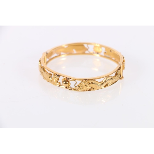 186 - Chinese gold bangle with pierced dragon chasing flamming pearl design, two character marks to interi... 