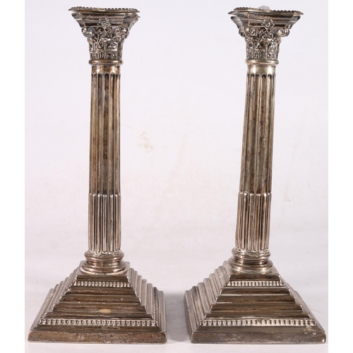 31 - Pair of George V sterling silver Corinthian column candlesticks, each with embossed capitals on bead... 