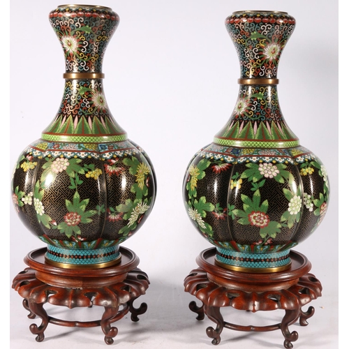 353 - A pair of early 20th century cloisonne vases with garlic top and lobed spherical body, the black gro... 